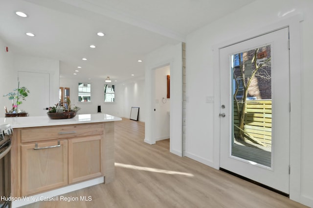 kitchen with light hardwood / wood-style floors, light brown cabinets, and electric stove