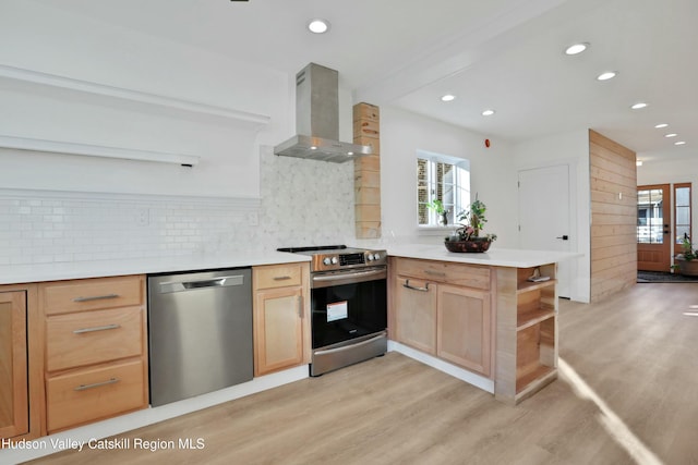 kitchen with appliances with stainless steel finishes, wall chimney range hood, decorative backsplash, light hardwood / wood-style floors, and kitchen peninsula