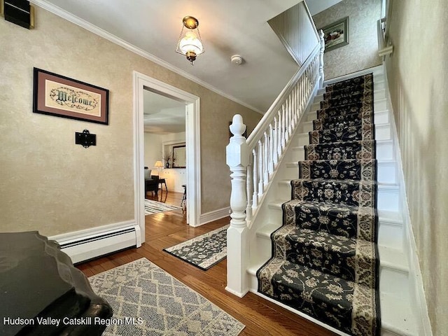 staircase with baseboards, wood finished floors, crown molding, and baseboard heating