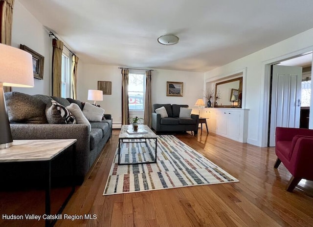 living room featuring plenty of natural light, wood finished floors, and a baseboard radiator