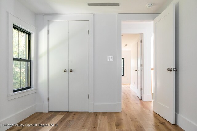 unfurnished bedroom with a closet and light hardwood / wood-style flooring