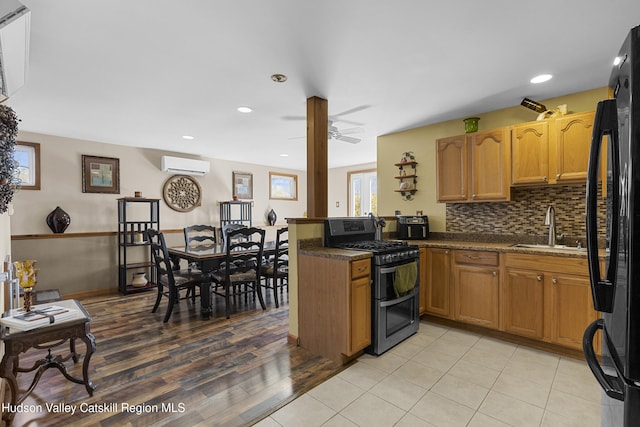 19 Pompeys Cave Rd, High Falls, NY 12440 - kitchen with double oven range, a sink, a wall mounted air conditioner, freestanding refrigerator, and a peninsula