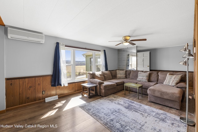 19 Pompeys Cave Rd, High Falls, NY 12440 - living area with a wall mounted AC, wood finished floors, ceiling fan, a wainscoted wall, and wood walls