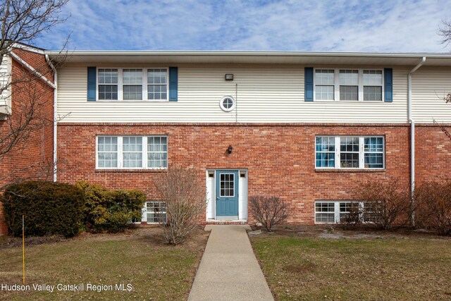 view of front of house with brick siding and a front yard