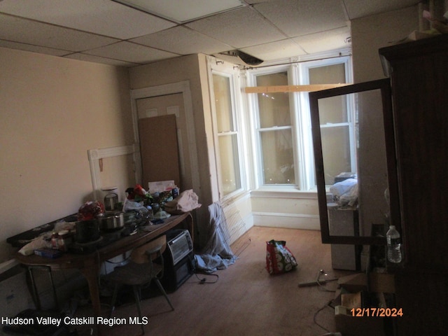 interior space with a drop ceiling and wood finished floors