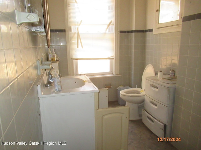 bathroom featuring tile walls, toilet, and vanity