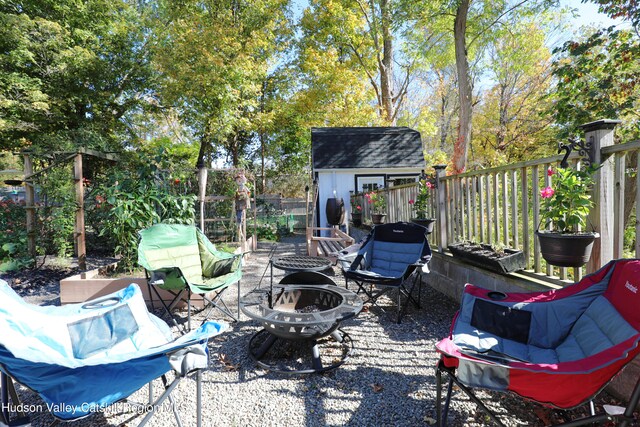 651 Glasco Tpke, Saugerties, NY 12477 - view of patio / terrace with a storage unit, an outdoor structure, a fenced backyard, and a fire pit