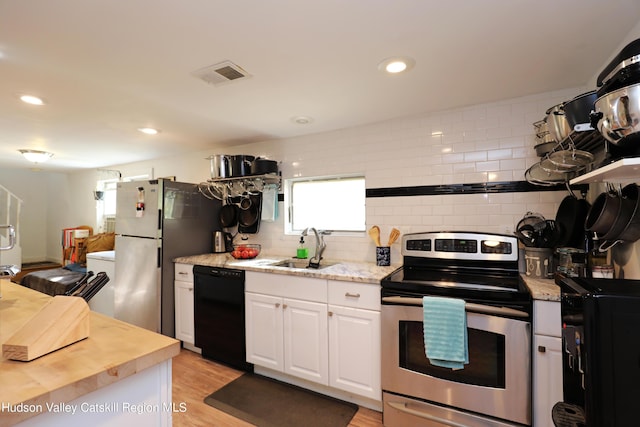 651 Glasco Tpke, Saugerties, NY 12477 - kitchen featuring a sink, stainless steel appliances, visible vents, white cabinetry, and backsplash