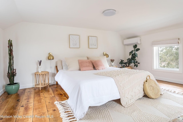 1637 Glasco Tpke, Woodstock, NY 12498 - bedroom featuring lofted ceiling, an AC wall unit, baseboards, and wood finished floors