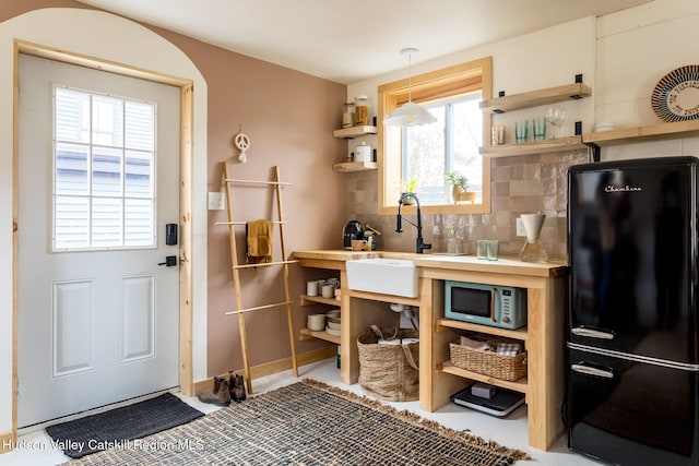 1637 Glasco Tpke, Woodstock, NY 12498 - kitchen featuring a sink, freestanding refrigerator, decorative light fixtures, open shelves, and backsplash