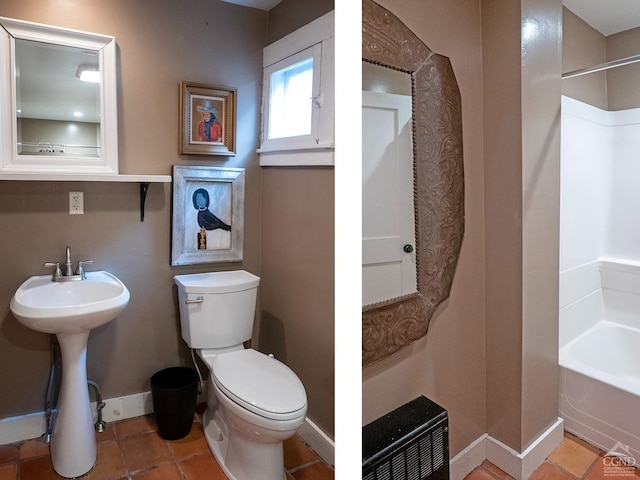 bathroom featuring toilet, baseboards, a sink, and tile patterned flooring