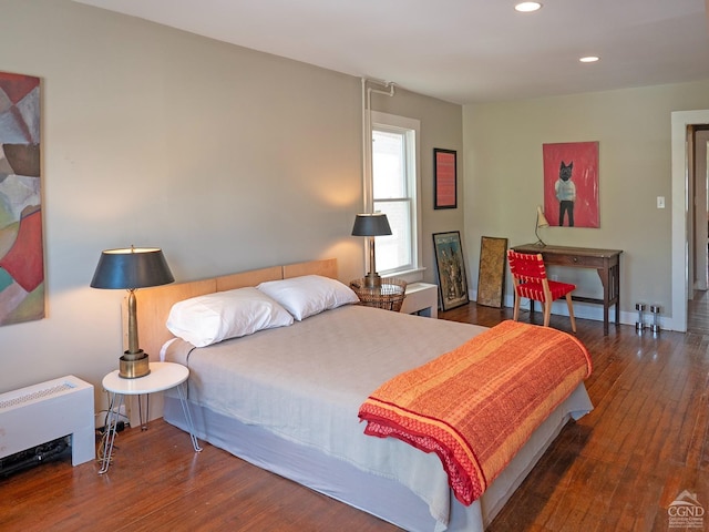 bedroom with radiator heating unit, recessed lighting, and hardwood / wood-style flooring