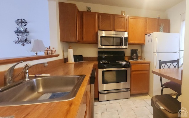 69 Windham Ridge Rd Unit 16F, Windham, NY 12496 - kitchen featuring appliances with stainless steel finishes, a sink, brown cabinetry, and light tile patterned floors