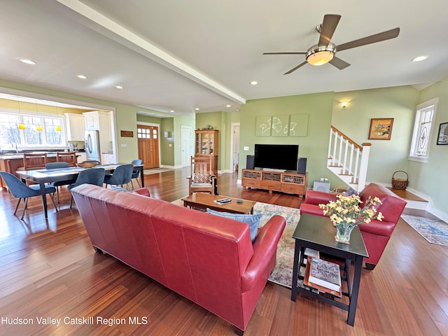 living area featuring recessed lighting, stairway, a wealth of natural light, and wood finished floors