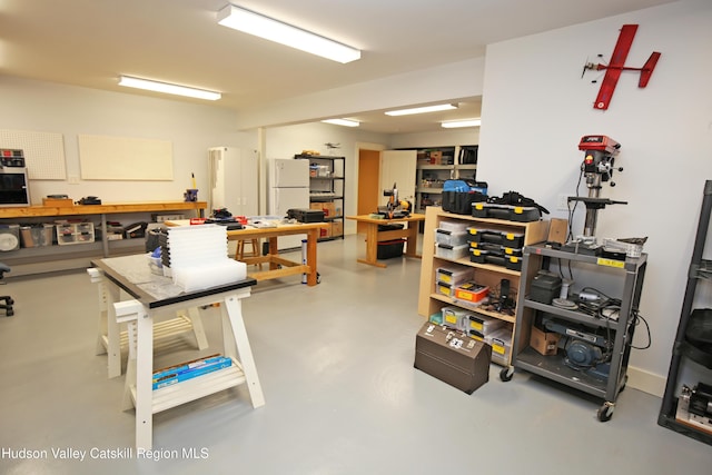 misc room with finished concrete floors and a workshop area