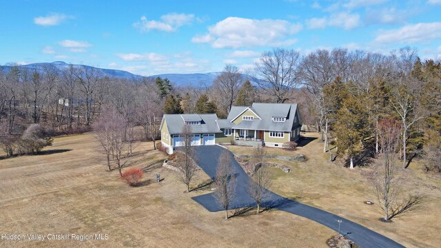 drone / aerial view with a mountain view and a view of trees