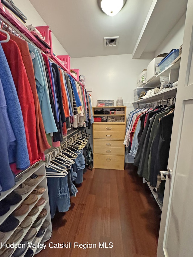 spacious closet with dark wood-style flooring and visible vents