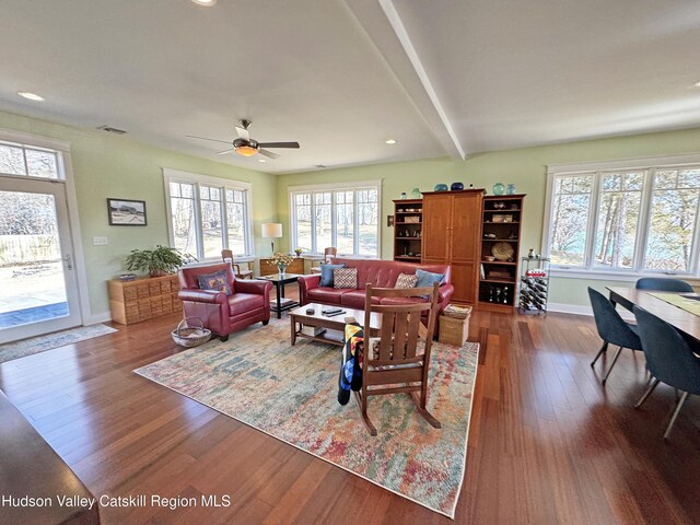 living room with baseboards, visible vents, dark wood-style floors, beamed ceiling, and recessed lighting