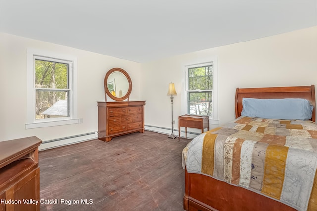 bedroom with multiple windows, baseboard heating, and wood finished floors