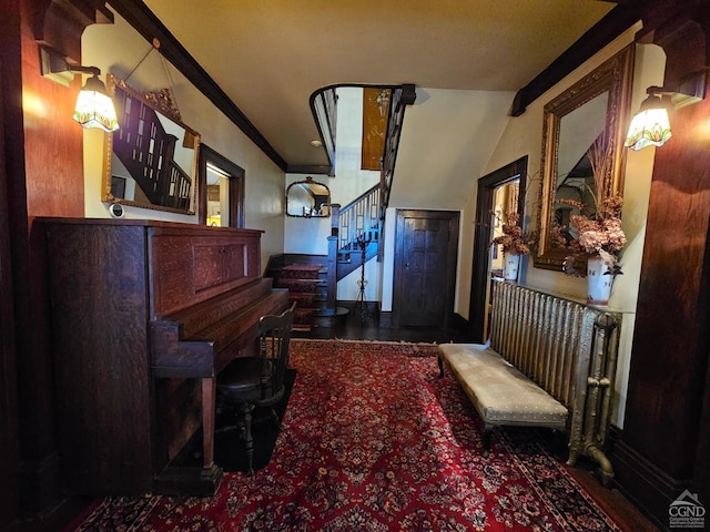 foyer with stairs, vaulted ceiling, and crown molding