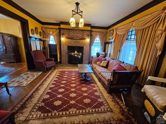 living room featuring healthy amount of natural light, wood finished floors, crown molding, and a fireplace