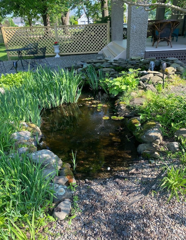 view of yard featuring a small pond and a deck