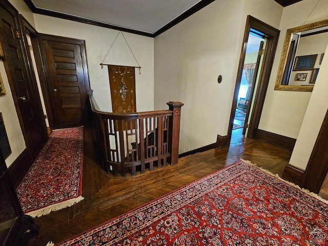 corridor with ornamental molding, baseboards, wood finished floors, and an upstairs landing