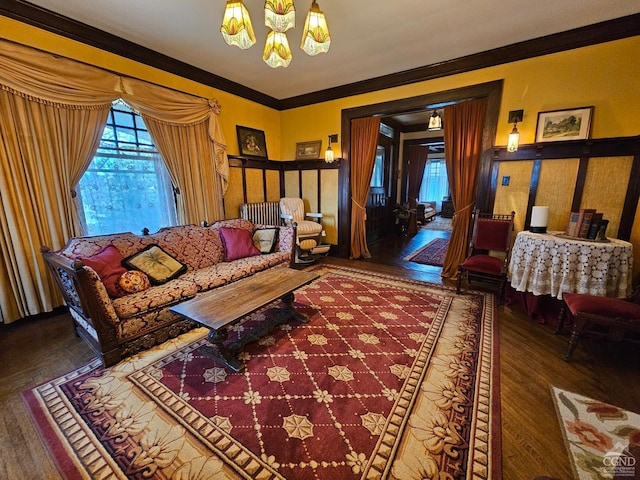 living area with a chandelier, wood finished floors, and crown molding