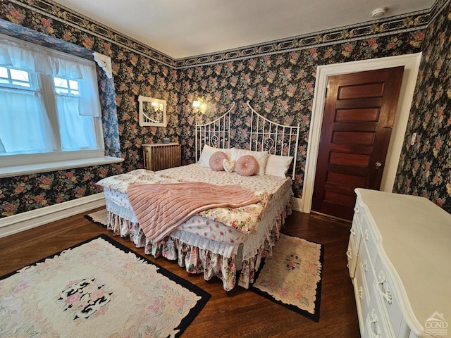 bedroom featuring wallpapered walls, baseboards, and dark wood-style flooring