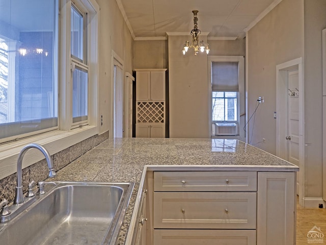 517-519 Washington St, Hudson, NY 12534 - kitchen featuring a sink, a chandelier, crown molding, a peninsula, and hanging light fixtures