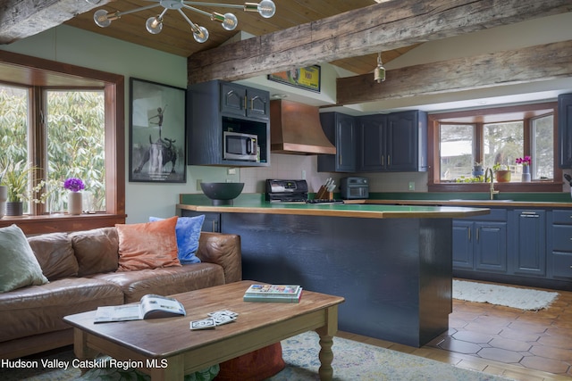 kitchen featuring sink, wood ceiling, stove, decorative backsplash, and wall chimney exhaust hood