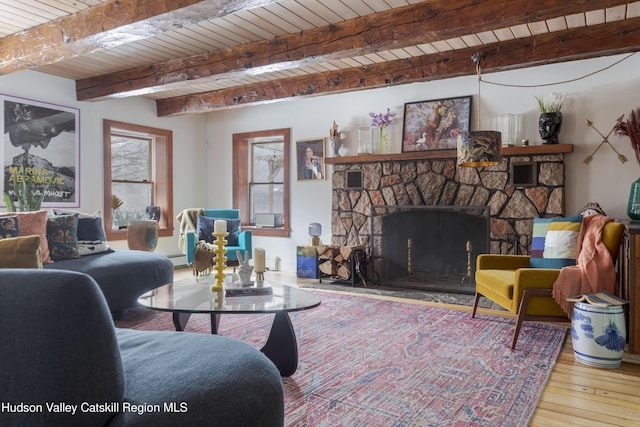 living room with beam ceiling, light wood-type flooring, a fireplace, and wood ceiling