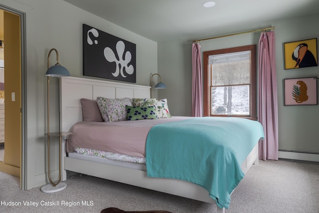 bedroom with a baseboard heating unit and carpet flooring