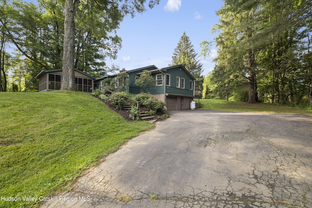 293 Pine Bush Rd, Stone Ridge, NY 12484 - view of front of property with a sunroom, an attached garage, asphalt driveway, and a front yard