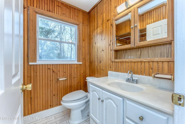 bathroom featuring wooden walls, vanity, and toilet