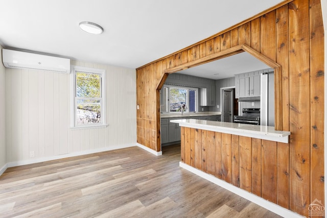4 Lawrence Ave, Coxsackie, NY 12051 - kitchen with an AC wall unit, electric stove, light wood finished floors, baseboards, and light countertops