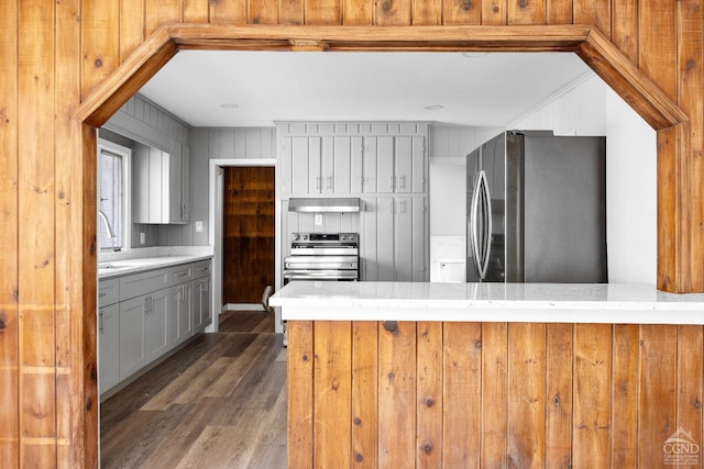 4 Lawrence Ave, Coxsackie, NY 12051 - kitchen featuring appliances with stainless steel finishes, ventilation hood, wood finished floors, light countertops, and wooden walls
