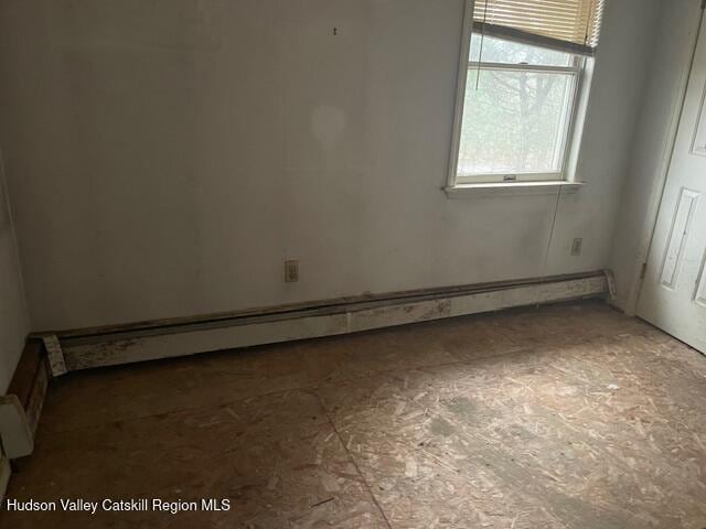 unfurnished room featuring a baseboard radiator