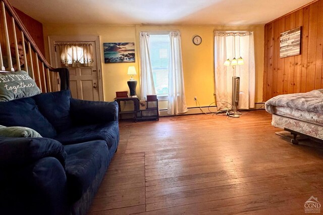 417 State St, Hudson, NY 12534 - living area featuring hardwood / wood-style floors, stairway, wood walls, and baseboard heating