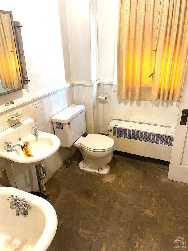 417 State St, Hudson, NY 12534 - bathroom featuring radiator, a wainscoted wall, toilet, and a sink