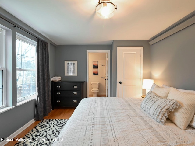 bedroom with ensuite bathroom and wood-type flooring