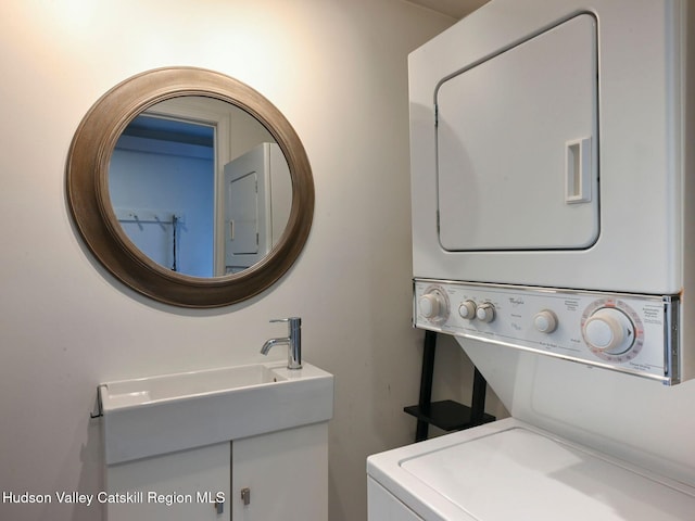 laundry area with stacked washer / drying machine and sink