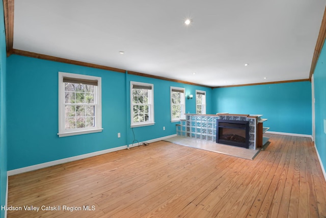 unfurnished living room featuring recessed lighting, a high end fireplace, wood-type flooring, crown molding, and baseboards