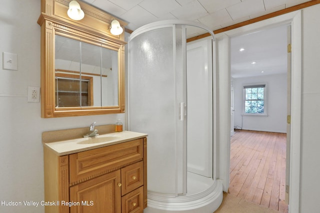 bathroom with hardwood / wood-style flooring, vanity, and a stall shower