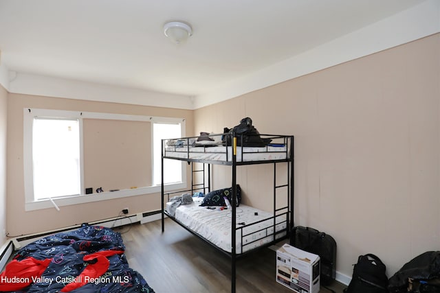 bedroom featuring wood finished floors and baseboard heating