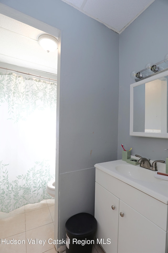 bathroom featuring tile patterned flooring, vanity, and toilet