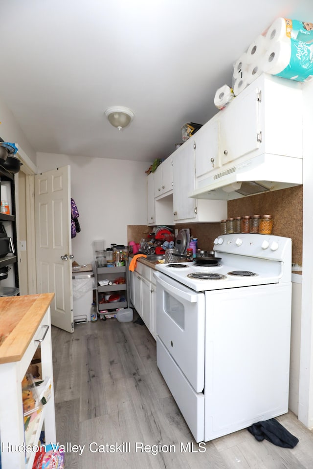 kitchen featuring white electric range oven, light wood-style flooring, white cabinets, under cabinet range hood, and wooden counters
