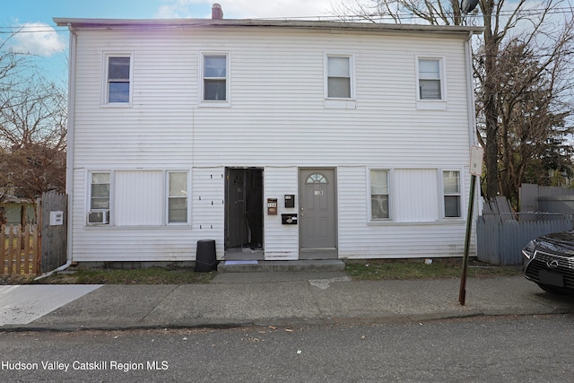 view of front of home featuring cooling unit and fence