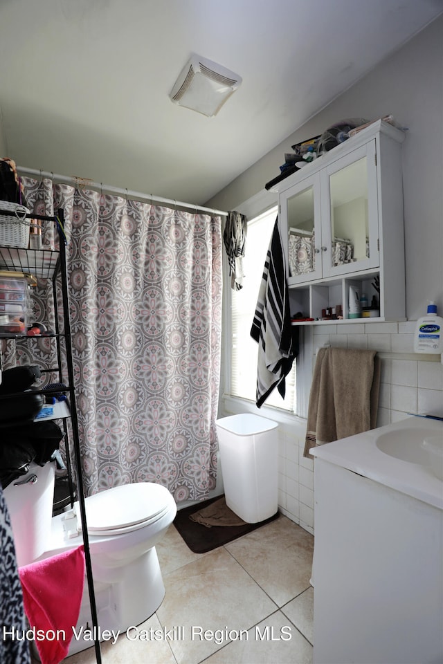 bathroom featuring tile walls, toilet, a shower with shower curtain, and tile patterned flooring