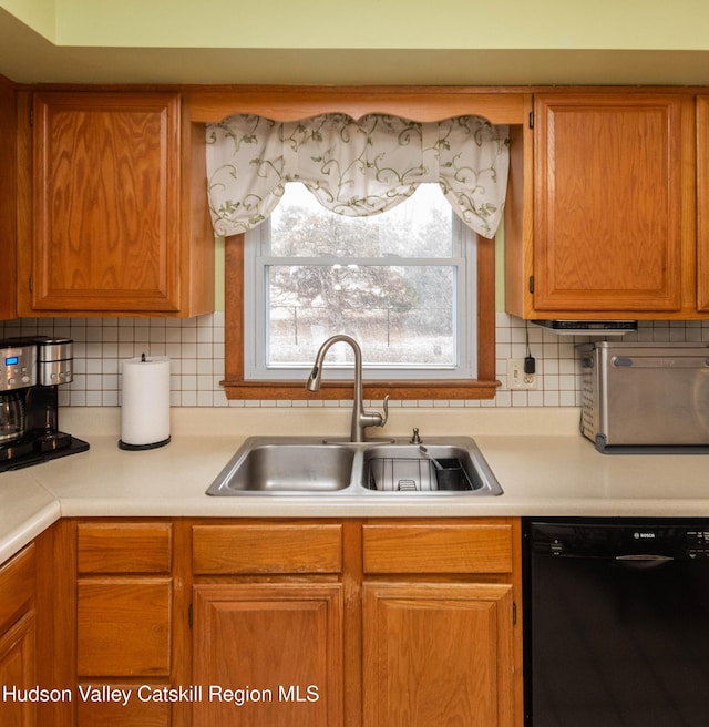 kitchen featuring backsplash, sink, and black dishwasher